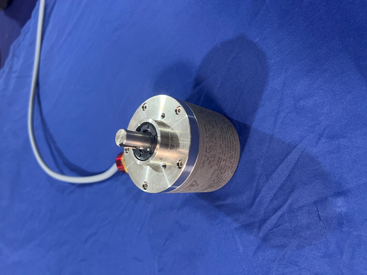 A round metal object with a wire

Description automatically generated